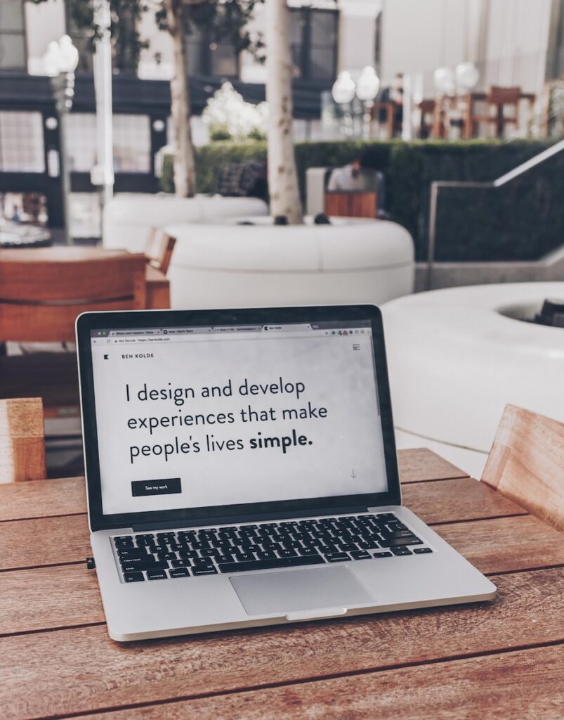 Laptop with page open saying 'I design and develop experiences that make people's lives simple.'